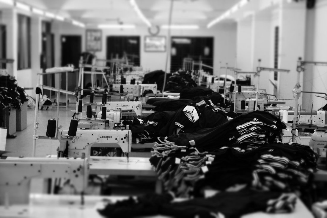 Garment factory floor with sewing machines and finished garments